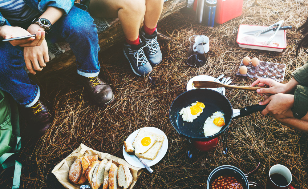 Delicious campfire breakfast spread with eggs, bacon, and coffee