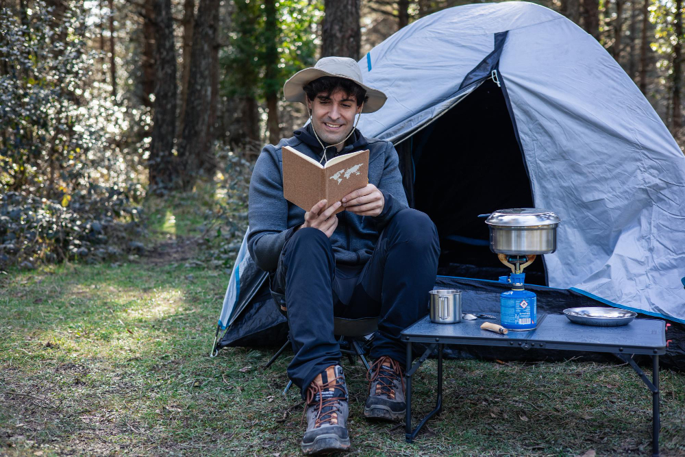 Camper reviewing a map and safety instructions sitting in a tent entrance